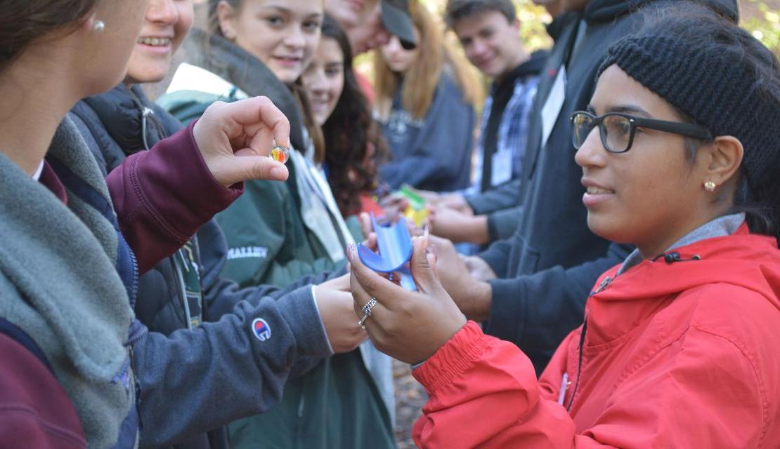 High school students do a team building exercise with marbles during Youth in Motion at East Campus.